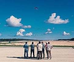 A group of observers watching a Colibrex drone flight during a measurement mission near a runway in Mexico for SENEAM